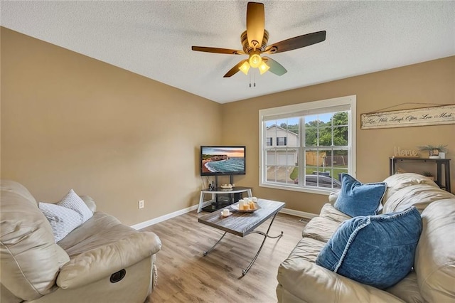 living room with baseboards, a textured ceiling, ceiling fan, and wood finished floors