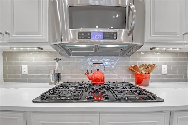 kitchen featuring decorative backsplash, white cabinetry, black gas cooktop, and light countertops