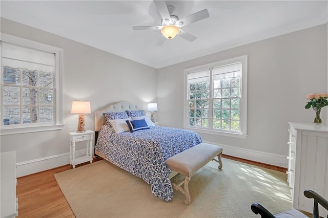 bedroom featuring ornamental molding, ceiling fan, baseboards, and wood finished floors