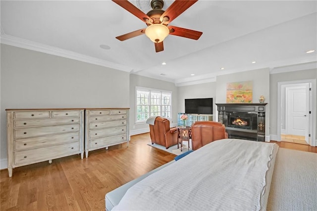 bedroom with a glass covered fireplace, wood finished floors, recessed lighting, and ornamental molding