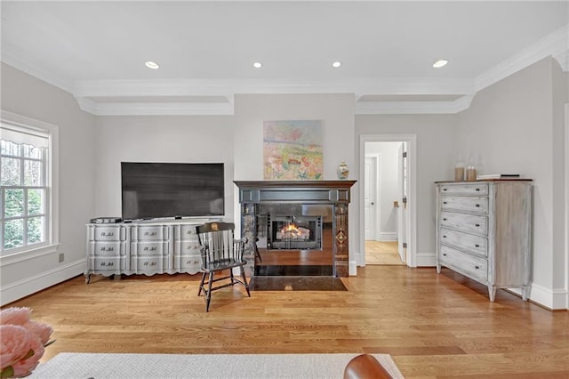 living room featuring a glass covered fireplace, wood finished floors, and ornamental molding