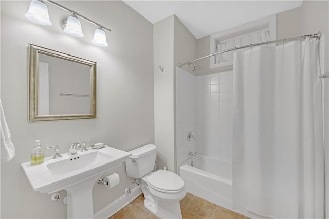 bathroom featuring tile patterned floors, toilet, shower / tub combo, and a sink