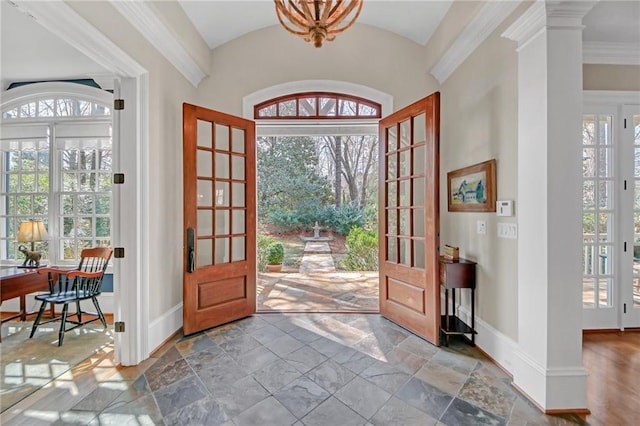 foyer entrance featuring lofted ceiling, stone tile floors, french doors, and baseboards