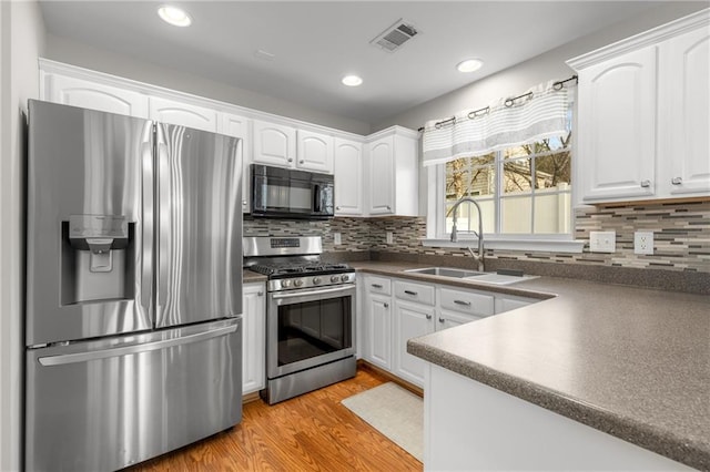 kitchen with white cabinetry, sink, light hardwood / wood-style flooring, and stainless steel appliances