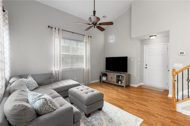 living room with hardwood / wood-style floors, high vaulted ceiling, and ceiling fan