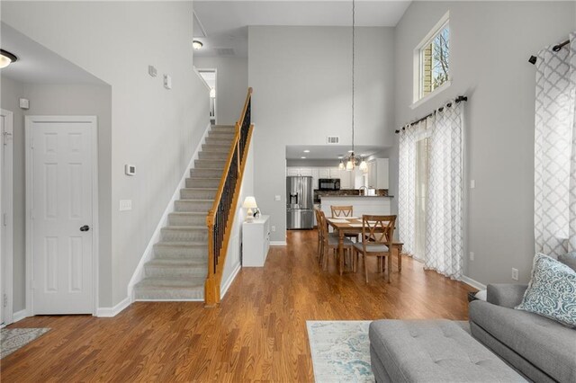 interior space with a healthy amount of sunlight, light hardwood / wood-style floors, and a high ceiling