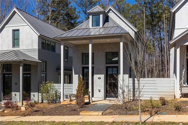 view of front of home with a standing seam roof, metal roof, and covered porch