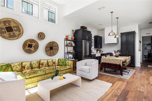 living area featuring light wood-style flooring and visible vents