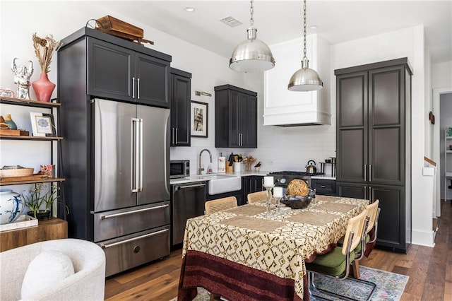 kitchen featuring a sink, visible vents, light countertops, appliances with stainless steel finishes, and pendant lighting