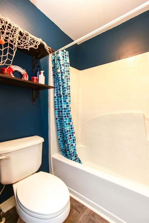 full bathroom with wood finished floors, shower / bath combo with shower curtain, and toilet