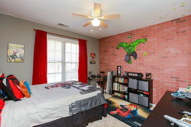 carpeted bedroom featuring a ceiling fan, visible vents, and brick wall