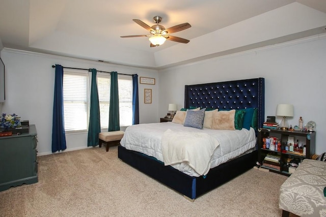 carpeted bedroom with a tray ceiling, ceiling fan, and baseboards