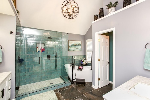 full bath featuring a notable chandelier, vanity, a shower stall, a freestanding tub, and tile patterned floors