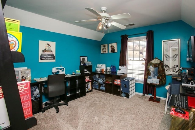 office featuring vaulted ceiling, light carpet, visible vents, and a ceiling fan