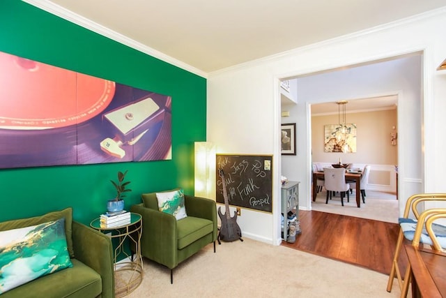 sitting room featuring ornamental molding, carpet, wood finished floors, and baseboards