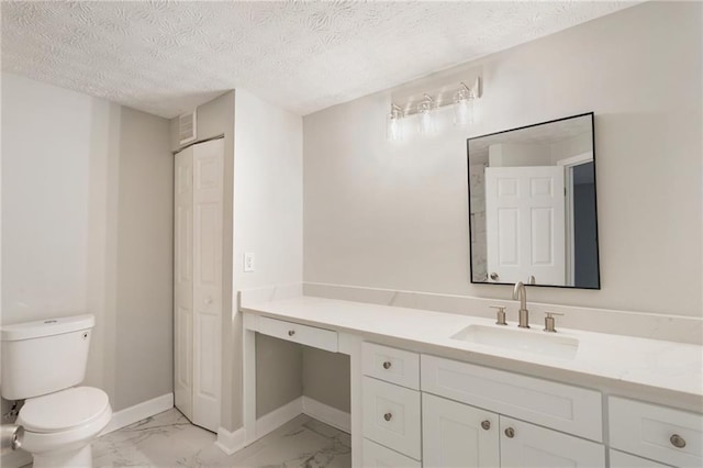 bathroom with marble finish floor, a closet, toilet, vanity, and baseboards