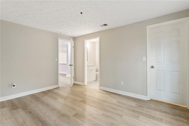 unfurnished bedroom featuring visible vents, light wood-style flooring, and baseboards