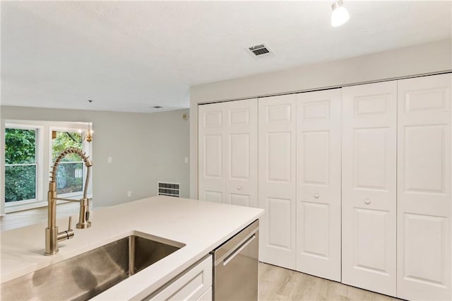 4315 Orchard Park Ct, Stone Mountain, GA 30083 - kitchen featuring stainless steel dishwasher, a sink, light wood finished floors, light countertops, and white cabinets
