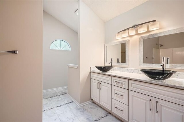 2068 Bedford Ct, Lithonia, GA 30058 - full bath with a sink, baseboards, lofted ceiling, and double vanity