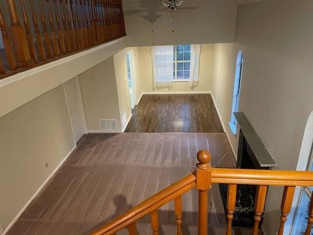 interior space with stairway, wood finished floors, baseboards, visible vents, and ceiling fan