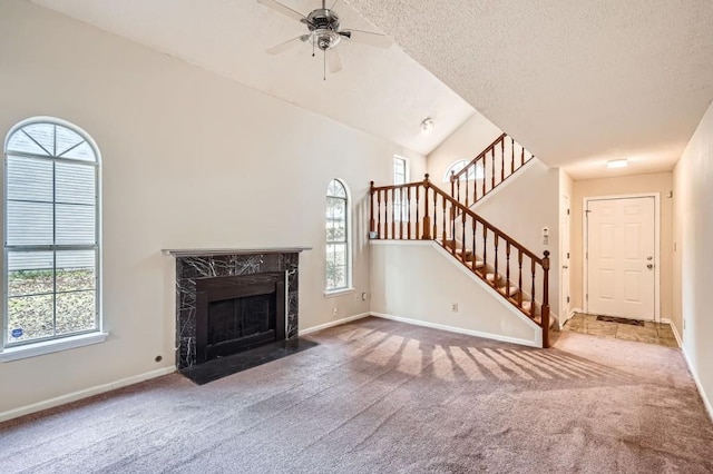 unfurnished living room with a premium fireplace, carpet, baseboards, and ceiling fan