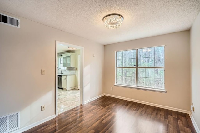 unfurnished room featuring visible vents, baseboards, and dark wood-style flooring