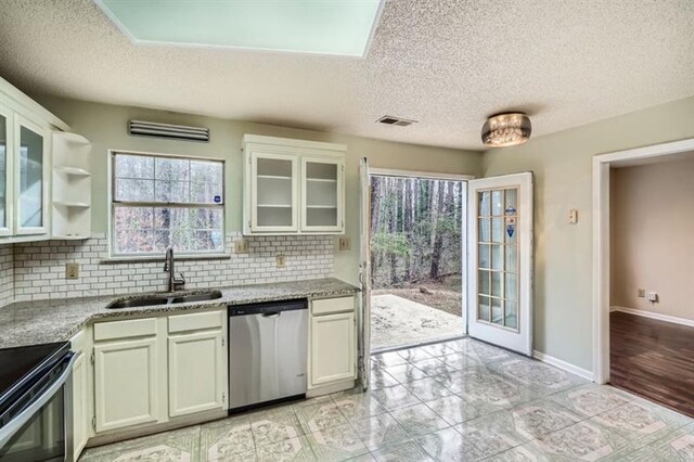 2068 Bedford Ct, Lithonia, GA 30058 - kitchen with a sink, tasteful backsplash, appliances with stainless steel finishes, glass insert cabinets, and baseboards