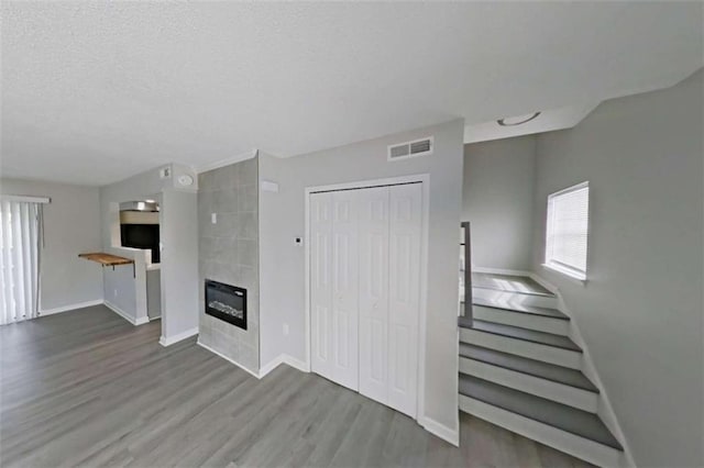 4701 Flat Shoals Rd Unit 50A, Union City, GA 30291 - unfurnished living room with baseboards, wood finished floors, a textured ceiling, a fireplace, and stairs