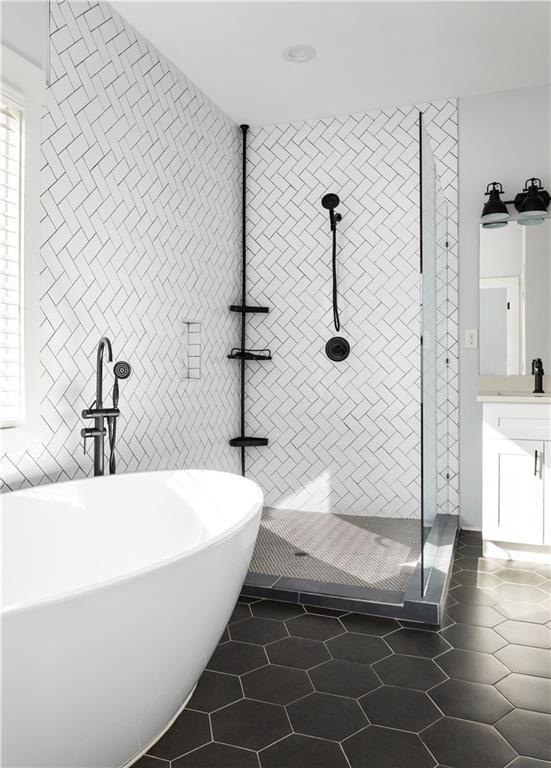 bathroom featuring vanity, tile walls, tile patterned floors, and plus walk in shower