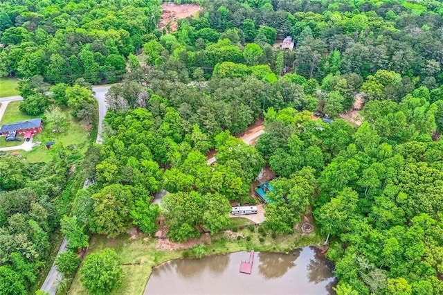 drone / aerial view with a water view and a forest view