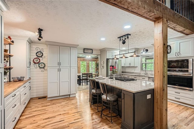 kitchen featuring a healthy amount of sunlight, stainless steel appliances, and a textured ceiling
