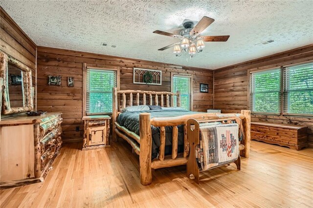 bedroom with visible vents, a ceiling fan, a textured ceiling, and wood finished floors