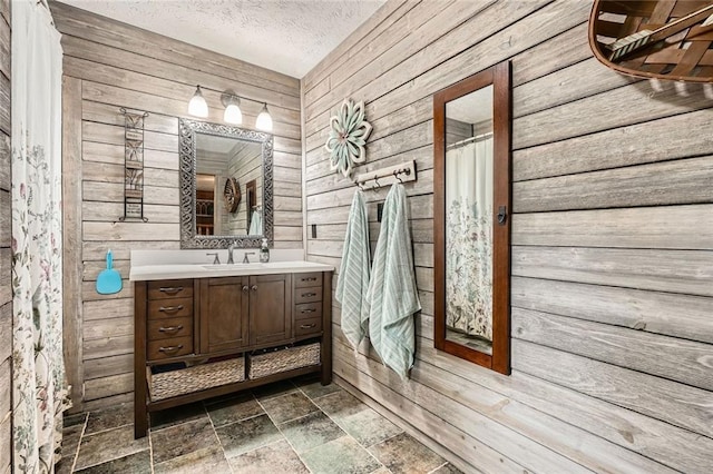 full bath with wood walls, stone finish floor, and vanity