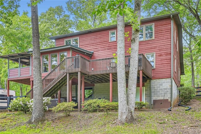 rear view of property featuring stairway and a wooden deck