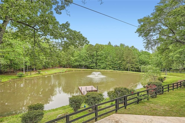 water view with fence and a wooded view