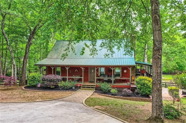 rustic home with covered porch and metal roof