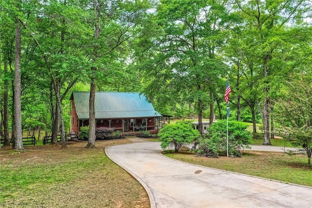 view of community with aphalt driveway and fence