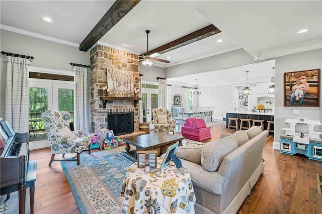 829 Christopher Rd, Sharpsburg, GA 30277 - living area with beam ceiling, a ceiling fan, wood finished floors, crown molding, and a stone fireplace