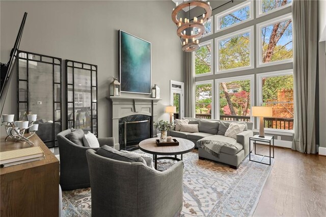3749 Watkins Pl NE, Brookhaven, GA 30319 - living room featuring a high ceiling, a chandelier, a fireplace, and wood finished floors