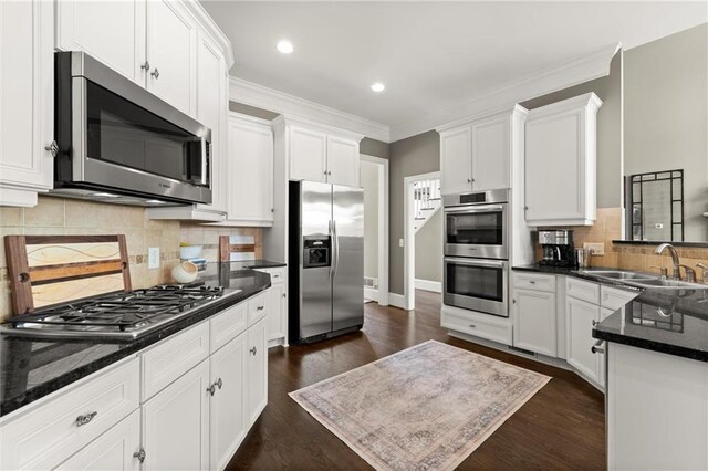 3749 Watkins Pl NE, Brookhaven, GA 30319 - kitchen with stainless steel appliances, a sink, white cabinets, ornamental molding, and recessed lighting