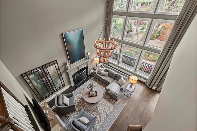 3749 Watkins Pl NE, Brookhaven, GA 30319 - living room featuring a high ceiling, healthy amount of natural light, wood finished floors, a chandelier, and a premium fireplace