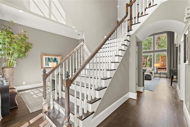 3749 Watkins Pl NE, Brookhaven, GA 30319 - staircase with a high ceiling, baseboards, arched walkways, and wood finished floors