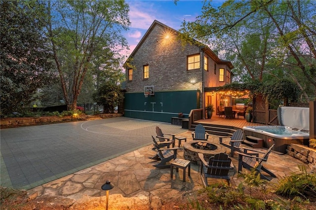 3749 Watkins Pl NE, Brookhaven, GA 30319 - back of house at dusk featuring a fire pit, a hot tub, a deck, and a patio