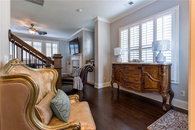 sitting room with crown molding, ceiling fan, dark wood finished floors, baseboards, and visible vents