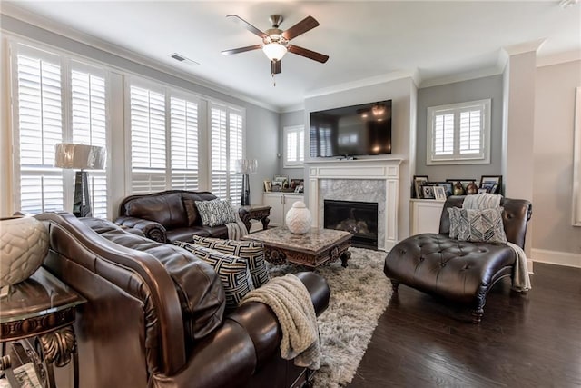 living area featuring a premium fireplace, a ceiling fan, wood finished floors, and crown molding