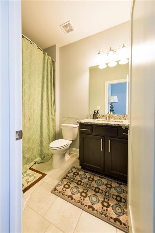 full bath featuring tile patterned floors, toilet, visible vents, a shower with shower curtain, and vanity