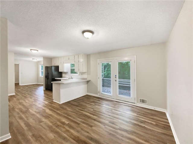 kitchen with visible vents, black fridge, french doors, and dark wood-style flooring