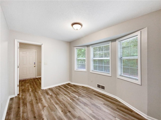 spare room with hardwood / wood-style floors and a textured ceiling