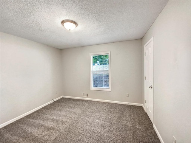 carpeted empty room featuring visible vents, baseboards, and a textured ceiling