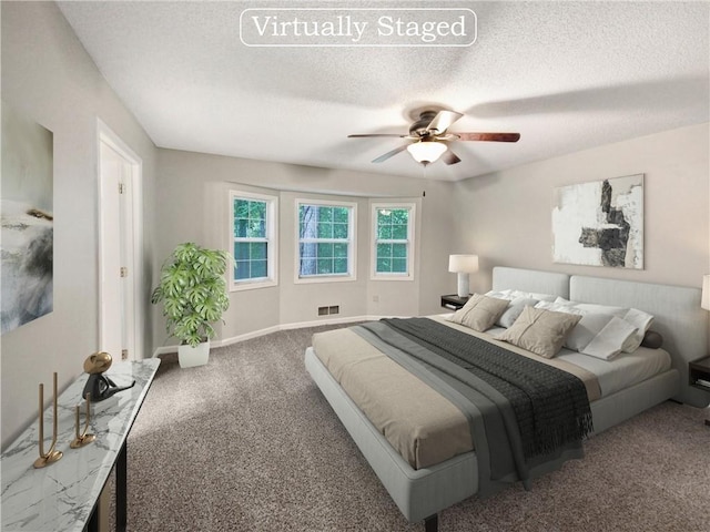 carpeted bedroom with visible vents, baseboards, a textured ceiling, and a ceiling fan